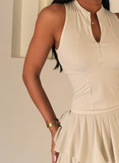 Woman wearing a beige dress with a plain background