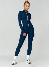 Woman wearing a blue athletic outfit on a gray background