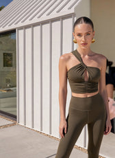 Woman in a green outfit standing in front of a modern building