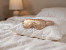 Silk eye mask and headband styled on a bed, lifestyle photo