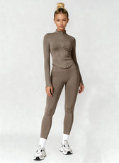 Woman wearing a brown athletic outfit on a white background